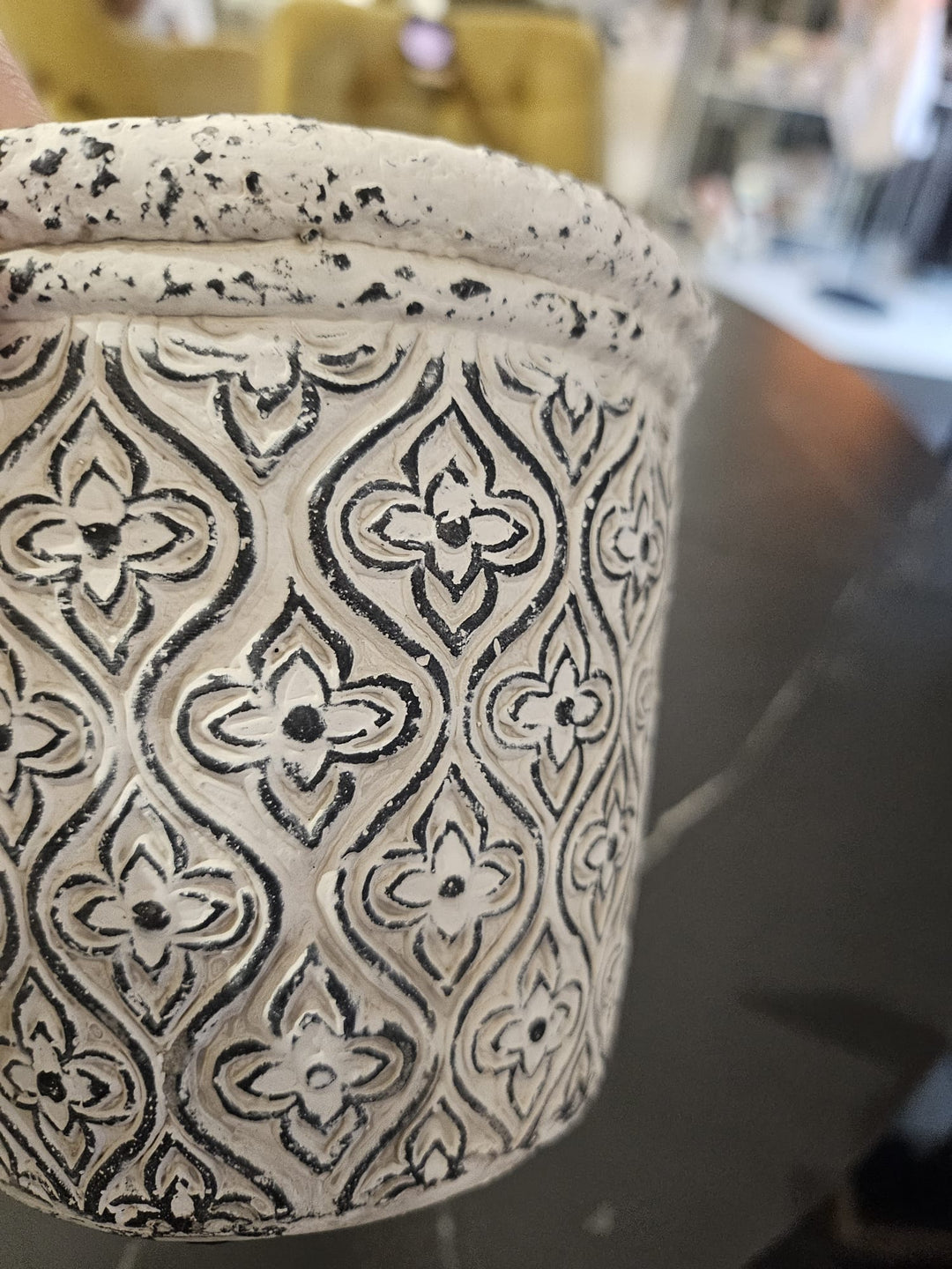 Keramikas puķpods ar melnu rakstu uz pelēka fona