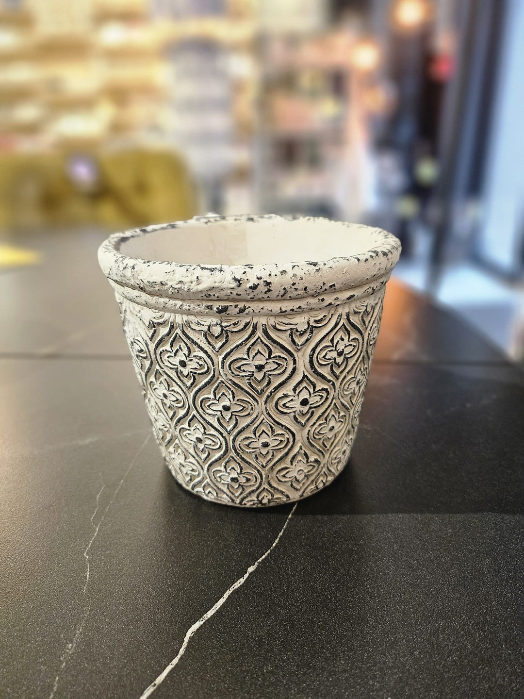 Keramikas puķpods ar melnu rakstu uz pelēka fona